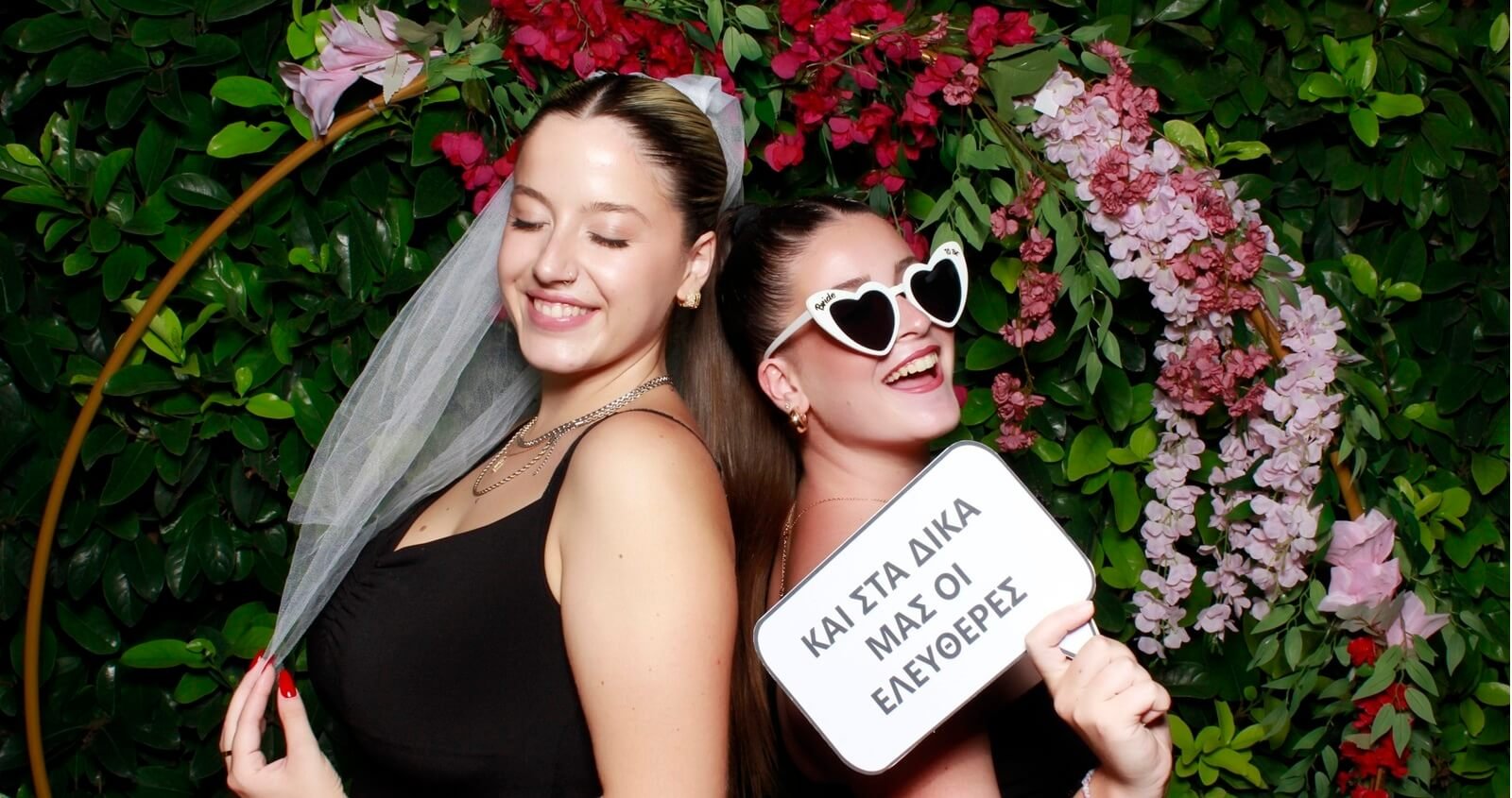2 girls posing in front of photobooth